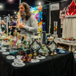Fred Schorsch behind table of glass art at tradeshow