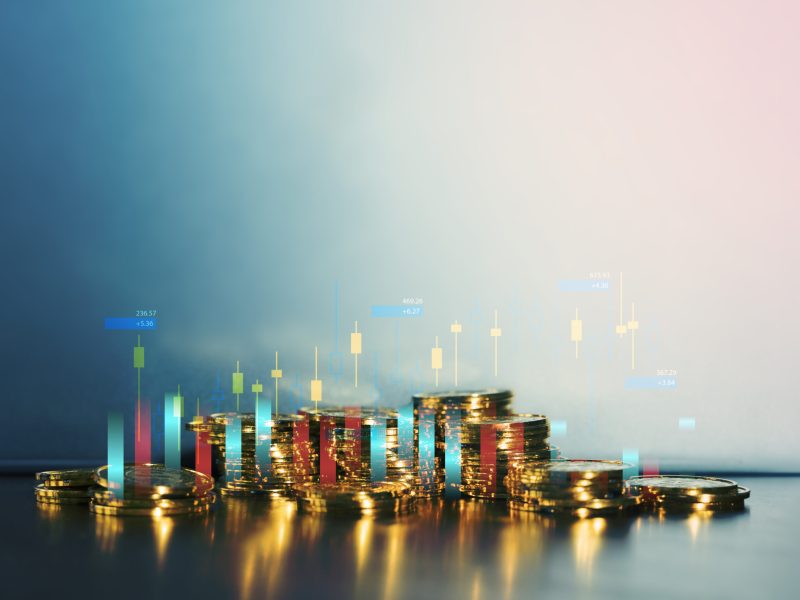 Shiny gold coins stacked on table with candlestick chart overlay, symbolizing cryptocurrency trading, financial market investment, forex analysis, digital economy, and long term wealth growth strategy