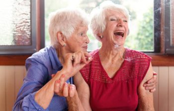 Two senior girlfriends 83 years old smoke medicinal marijuana together. One of them shows the other how to do. The old lady is surprise and making a face.. They have hair and wear casual clothes. The recreational marijuana become legal in Canada next autumn. Photo was taken in Quebec Canada.